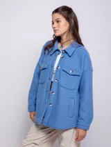 Sobrecamisa color beige de paño con cuello camisero, cierre frontal con botones veteados, dos bolsillos con solapa en el pecho y dos bolsillos laterales.