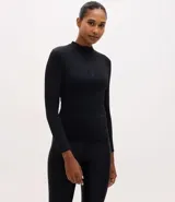 Remera deportiva de manga larga Get Over, confeccionada en tejido elástico de poliamida y elastano. Presenta un diseño ajustado al cuerpo, cuello alto y cierre frontal parcial con cremallera.