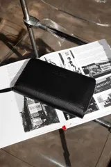 Billetera negra de cuero con cierre de cremallera, múltiples ranuras para tarjetas, compartimento para billetes y monedero con cremallera.