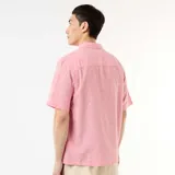 Camisa de manga corta confeccionada en mezcla de lino, de color rosado, con cuello camisero y cierre frontal con botones.