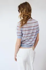 Top de punto fino de lana, de corte recto con mangas cortas y cuello redondo, con diseño de rayas horizontales en tonos celestes y bordó.