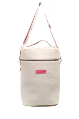 Bolso matero color crema con textura símil cuero, cierre superior con cremallera y correa de cinta con logo de la marca.