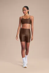 Biker deportiva de tiro alto confeccionada en tejido Allure con tecnología Lycra Adaptiv, de compresión media a alta, con acabado satinado y bolsillos laterales funcionales.