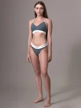 Bralette Calvin Klein de algodón elástico, color gris azulado, con copas ligeramente acolchadas y sin aros. Presenta banda elástica inferior con logo y tirantes ajustables con logo.