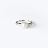Anillo de plata 925 con una perla de río central y engarce de circonias en los laterales.