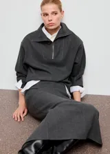 Falda midi gris oscuro, de tiro alto y corte recto, con abertura discreta en la parte posterior.