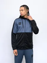 Canguro Umbro de hombre con cierre frontal completo, capucha y diseño bicolor en azul y negro. Presenta cortes en los hombros y mangas, y un logo de Umbro en el pecho.