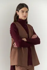 Chaleco azul con cuello en V y cierre frontal con botones marrones.