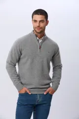 Buzo tejido de lana con cuello alto y medio cierre metálico frontal. Presenta puños y ruedo acanalados, con logo bordado en el pecho.