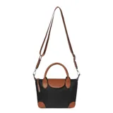 Cartera tipo tote pequeña de la marca Las Oreiro, confeccionada en poliéster negro con detalles en cuero sintético color suela en las asas, solapa frontal, base y correa. Cuenta con cierre principal, doble asa de mano y correa larga ajustable y extraíble para usar como bandolera.