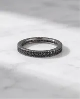 Anillo tipo cinta fabricado en plata 925, con diseño pavé de pequeñas piedras negras incrustadas en toda su superficie.