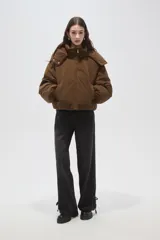 Campera puffer de pana color marrón, con cuello alto, capucha desmontable, cierre frontal y bolsillos laterales. Presenta un diseño holgado con puños elásticos.