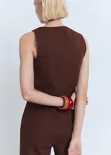 Top de corte recto y ajustado al cuerpo, color marrón, con tirantes anchos, cuello cuadrado y cierre frontal con botones a tono.