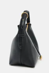 Mini bolso de mano con formato saca, confeccionado en tejido de rafia natural. Cuenta con un asa de mano ajustable en color marrón oscuro, cierre mediante cremallera metálica y detalle de doble tira frontal con terminaciones en forma de bolas.