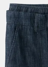 Pantalón de mezclilla azul oscuro, con silueta wide leg, tiro alto y pretina con cordón ajustable.