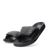 Sandalia tipo slide negra, con tira ancha ajustable mediante velcro. La tira presenta un patrón geométrico en relieve que simula el logo de Umbro.