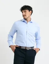 Camisa de vestir de manga larga en color celeste, con cuello clásico y cierre frontal de botones.