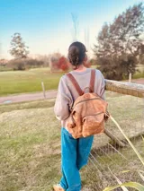 Mochila marrón de cuero con efecto gastado, múltiples bolsillos con cierre y correas ajustables.