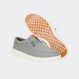 Zapatos de lona azul con detalles en cuero color suela en el talón y lengüeta. Presentan un diseño de estilo náutico con cordones elásticos, costuras reforzadas en la puntera y suela blanca de goma flexible.