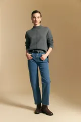 Polera de tejido de punto color blanco, con cuello alto acanalado, hombros caídos y detalle de costura vertical en el frente.