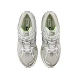 Championes New Balance modelo 1906R, de diseño técnico y deportivo en tonos gris, blanco y plateado, con detalles en verde lima. Presenta una estructura de malla transpirable con refuerzos sintéticos y entresuela amortiguada.