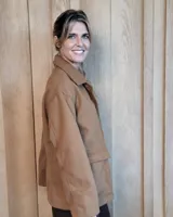 Sobrecamisa de paño color beige, con cuello solapa, cierre frontal de botones y dos bolsillos delanteros con solapa.