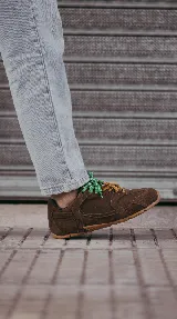 Zapatillas urbanas de cuero marrón con suela de goma y cordones intercambiables.