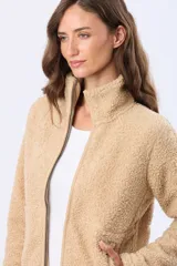 Campera de abrigo de corderito color beige, con cuello alto, cierre frontal y bolsillos laterales.