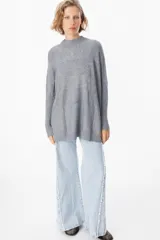 Sweater crudo de punto con cuello alto y mangas largas con puños ajustados.