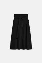 Falda midi color negro de tiro medio con bolsillos laterales ocultos, diseño evasé y cierre lateral con cremallera. Incluye un cinturón ajustable del mismo tejido.