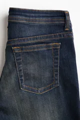 Jean de corte acampanado y tiro ultra bajo en denim azul oscuro con efecto desteñido y leve elasticidad.