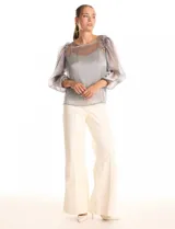 Blusa de organza translúcida con acabado satinado, mangas estilo balloon con volados en los hombros y puños elastizados. Incluye musculosa interna a tono.