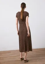 Vestido midi marrón con estampado de lunares claros, escote en V, manga corta y detalle de nudo en el pecho.