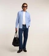 Camisa de manga larga blanca, corte slim fit, con cuello tradicional y abotonadura frontal.