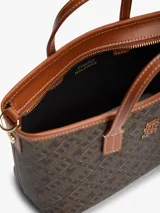Cartera tote Tommy Hilfiger de acabado texturizado con estampado integral del monograma TH en tonos marrón y negro. Cuenta con dos asas superiores de cuero sintético tostado, bandolera extraíble, cierre de cremallera y herrajes metálicos dorados. Incluye una insignia del monograma en el frente y un detalle de anilla en D.