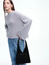 Sweater de tejido de punto con mezcla de mohair, color gris, con lentejuelas sutiles incorporadas. Presenta cuello redondo, hombros caídos y mangas largas con diseño acampanado.