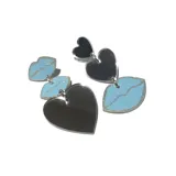 Par de aros colgantes asimétricos con forma de corazón y labios. Uno de los aros tiene un corazón grande plateado y un labio celeste con borde plateado. El otro aro tiene un labio celeste con borde plateado y un corazón pequeño plateado.