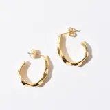 Aros tipo argolla color dorado con diseño retorcido.