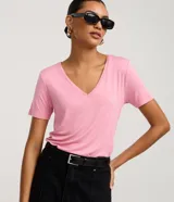 Blusa básica de manga corta con cuello en V, confeccionada en tejido de viscosa con elastano. Presenta un diseño liso y versátil, ideal para uso diario.