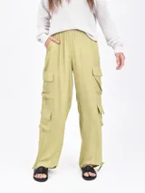 Pantalón cargo ancho de color verde oliva claro, con cintura elástica y bolsillos tipo parche a los lados de las piernas.