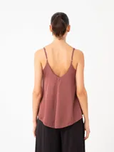 Top de viscosa color mostaza con escote en V y breteles finos regulables. Presenta un diseño minimalista de corte holgado y caída fluida.