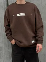 Buzo marrón de algodón con cuello redondo, puños y cintura acanalados. Estampa frontal con el logo de la marca en color blanco.