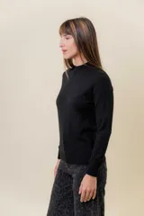 Buzo de tejido fino color amarillo claro, con cuello semi alto, manga larga y calce regular.