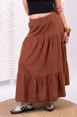 Pollera larga marrón de tiro alto con cintura elastizada y diseño escalonado con dos niveles de volados amplios.
