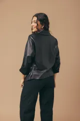 Camisa de cuero color fucsia, de corte recto, con cuello clásico y cierre frontal con botones.