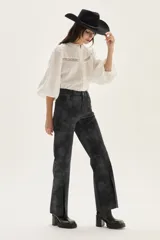 Pantalón wide leg de cuero sintético color marrón, con tajo frontal en el ruedo y cierre de botón y cremallera.