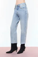 Jean de denim 100% algodón, color celeste, de calce Mom y tiro medio. Cuenta con remaches de flores niquel en borde de bolsillos delanteros y traseros, presillas delanteras y presilla central de espalda.