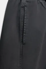 Pantalón de tiro bajo con cintura elástica ajustable mediante cordón, bolsillos delanteros y bolsillos de plastrón en la parte trasera.