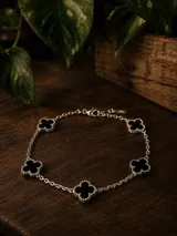 Pulsera de cadena rolo con cinco dijes en forma de trébol de cuatro hojas con incrustaciones de nácar blanco, enchapada en plata.