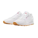 Championes Reebok Classic Leather blancos con detalles en rojo y suela de goma color caramelo.